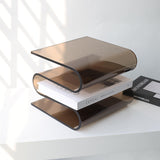 Archive smoke acrylic book stand by BAG&BONES displaying a coffee table book on a contemporary shelf.