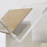 Detail of the clear acrylic frame and brushed brass shelf on the Folio magazine holder by BAG&BONES.