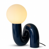 The Blue Lune Lamp sculptural table lamp with curved blue resin base and warm white glass globe