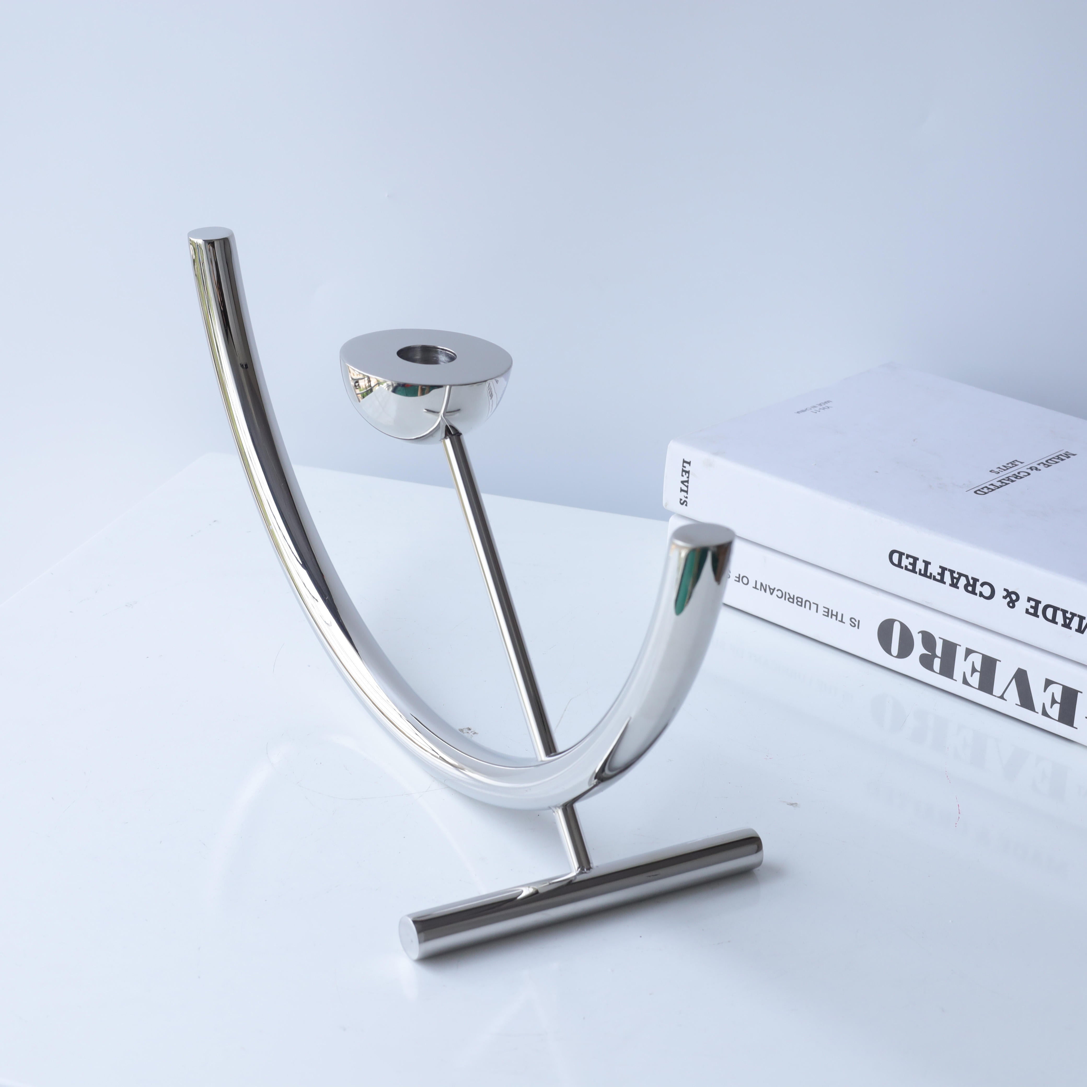 Orbit chrome candle holder by BAG&BONES featuring a sculptural stainless steel design styled on a tabletop in a contemporary interior.