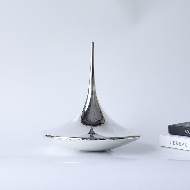 Teardrop sculptural object by BAG&BONES displayed on a coffee table in a contemporary living room with a polished stainless steel finish.