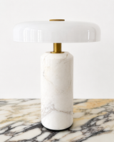 Design-led Muse table lamp featuring a white marble base, brass detailing and a glossy white rounded shade.