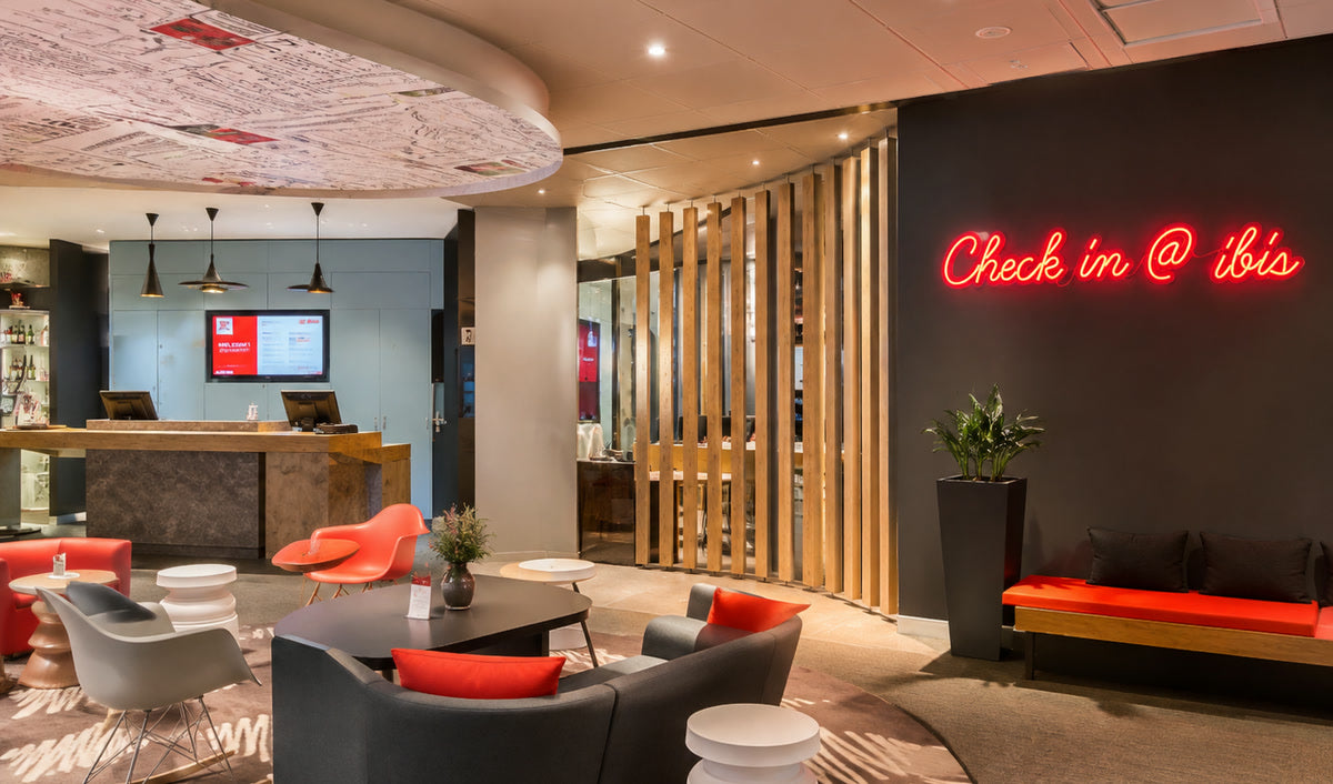 Red Check in at ibis neon sign in an ibis hotel reception